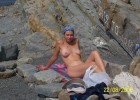 Nudist girl posing naked on rocky beach