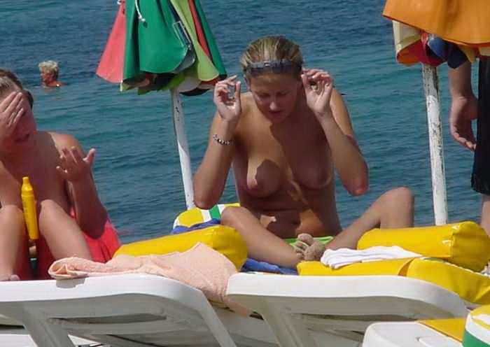 Topless hotties spied having a chitchat on the beach